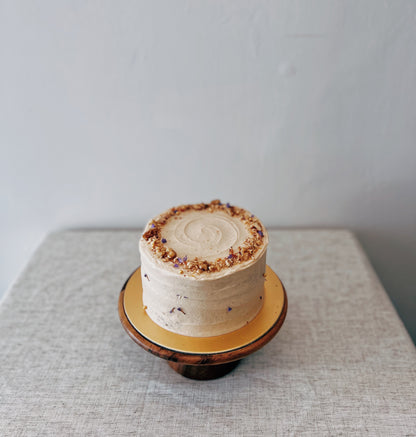 whole carrot walnut cake on wooden stand with textured frosting Singapore